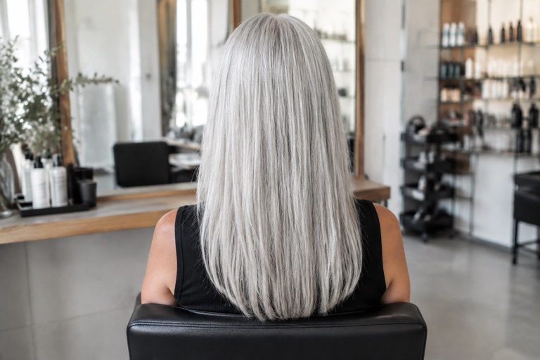 Rückansicht einer Frau mit langen grauen Haaren und gleichmäßigem Ton