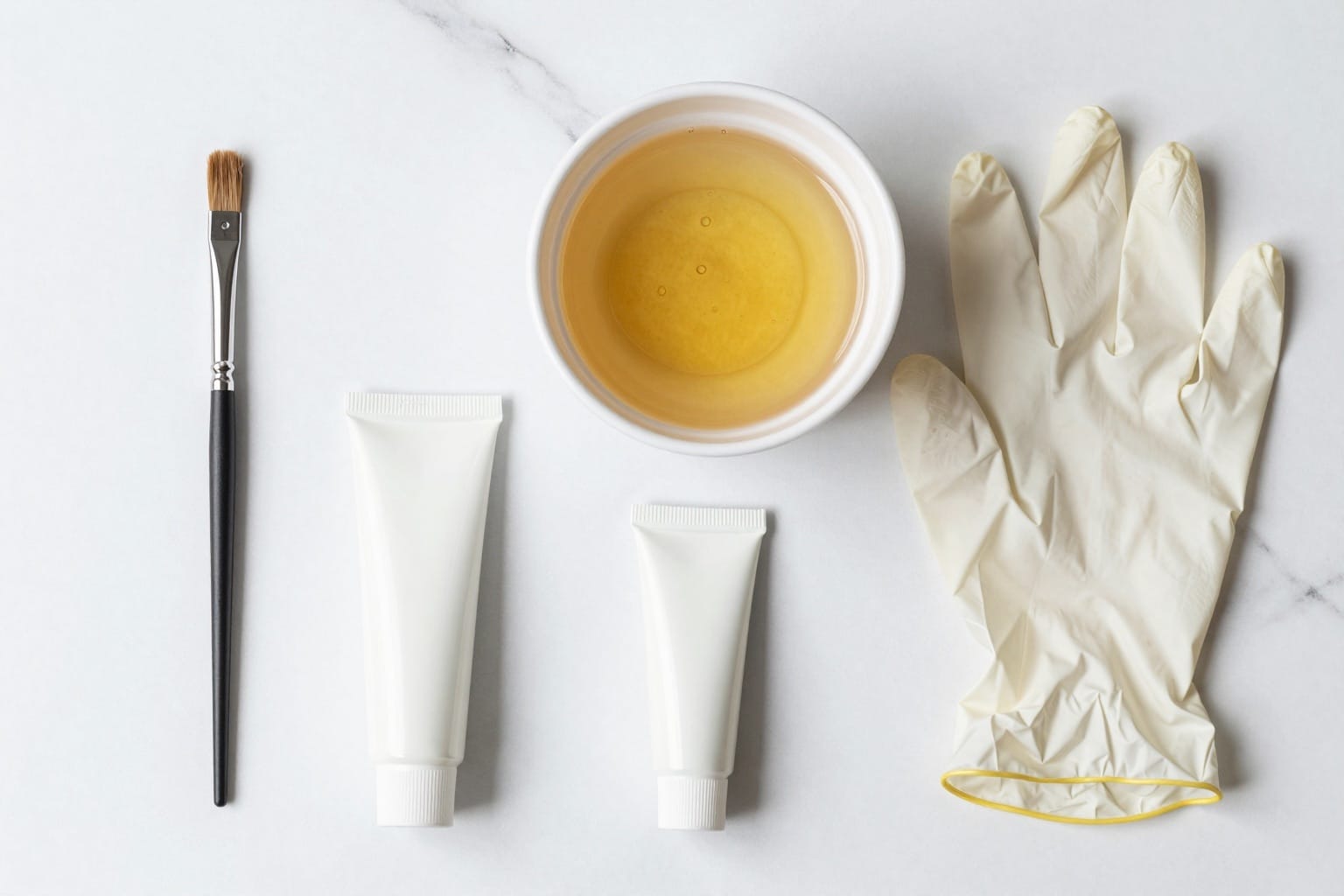 Färbeset für honigblonde Haare: Pinsel, Schale, Handschuhe und Farbe als Flatlay